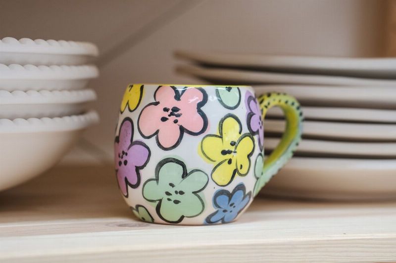 Fargerik kopp med blomstermotiv, laget på Lissom keramikkverksted på Teie